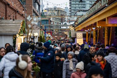 Crowd of people visiting the Christmas Village in the Distillery District. View of the Toronto Christmas Market. Toronto, Canada - December 24, 2024. clipart