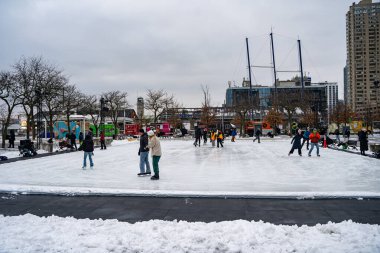 People skating at the Harbourfront Centre ice rink in Toronto. Toronto, Canada - December 24, 2024. clipart