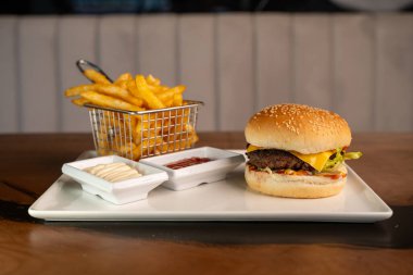 Restoranda patates kızartması, mayonez ve ketçap ile çizburger..