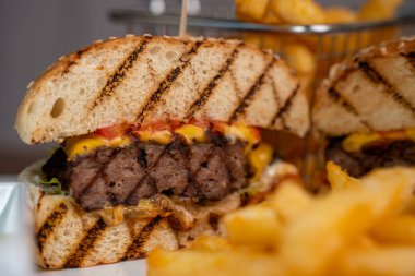 Lokantada sulu bir çizburgerin yakın çekimi..