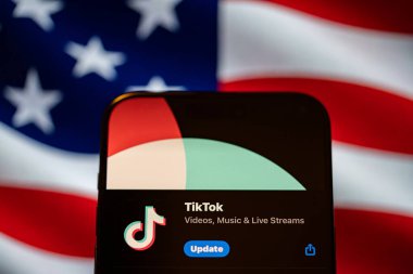 Arka planda Birleşik Devletler bayrağı olan bir telefonda TikTok uygulaması logosu. New York, ABD - 19 Ocak 2025.