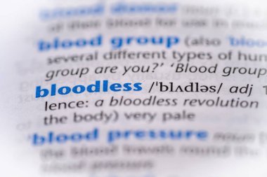 Bloodless word in a dictionary. Selective focus, close up. clipart