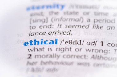 Ethical word in a dictionary. Selective focus, close up. clipart