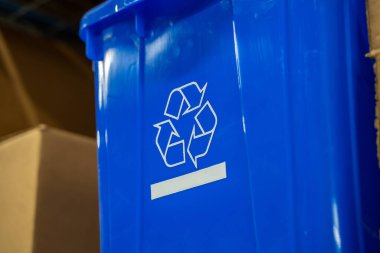 Mavi plastik bir kutunun üzerindeki geri dönüşüm sembolü.