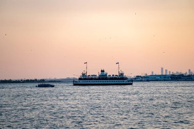 Toronto şehri feribot ve su taksisinin gün batımında Ontario Gölü 'nde görüntüsü. Toronto, Kanada - 21 Temmuz 2025.