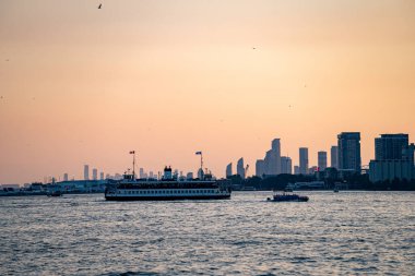 Toronto şehri feribot ve su taksisinin gün batımında Ontario Gölü 'nde görüntüsü. Toronto, Kanada - 21 Temmuz 2025.