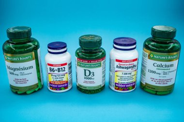 Mavi arka planda çeşitli sağlık malzemeleri ve vitaminler. Toronto, Kanada - 31 Temmuz 2025.