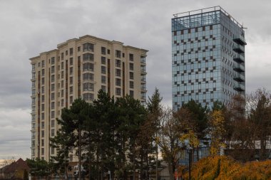 Bulutlu sonbahar gökyüzünde çekilmiş iki yeni binanın yakın çekimi.