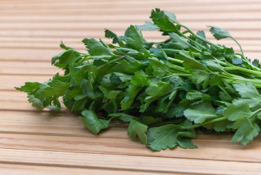 Sprigs of Fresh Parsley on Rustic Wooden Background.