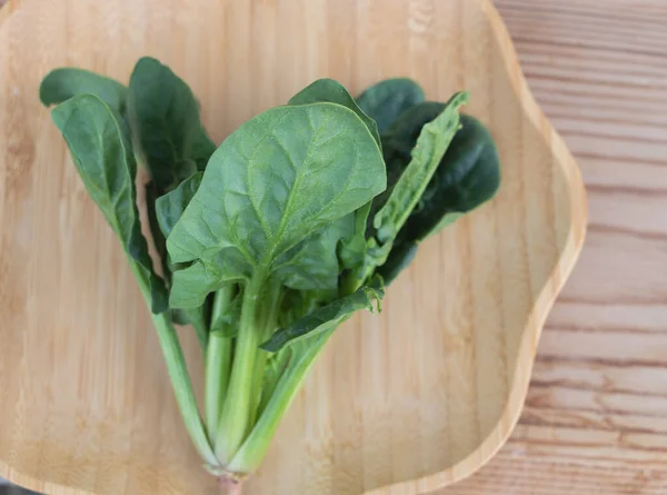 Spinach Daun Piring Kayu Pada Latar Belakang Meja Kayu Konsep — Stok Foto