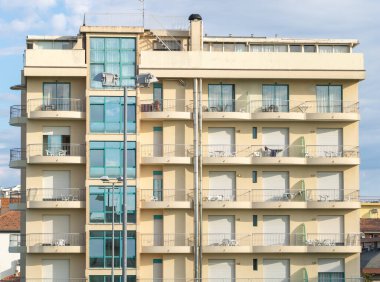 Mavi gökyüzünün arka planında modern bir apartmanın cephesi.