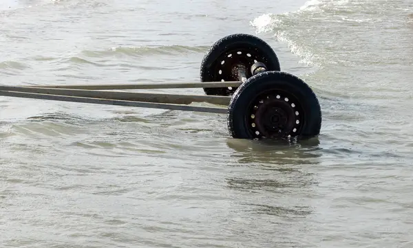 Truck tires on the water of the sea, closeup of photo.