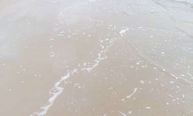 Kumsalda deniz dalgası, fotoğrafa yakın çekim. Doğal arkaplan.