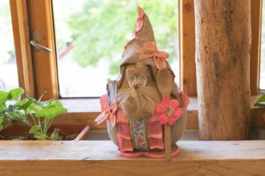 Pencerenin önündeki ahşap rafta şapkalı Paskalya tavşanı..