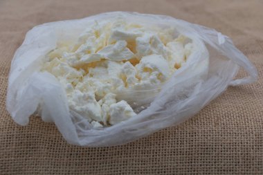 Çuval bezi arka planda yumuşak beyaz bir peynir torbası..