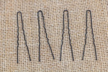 A set of hair pins, with a straight line shape, made of steel material, in black color.