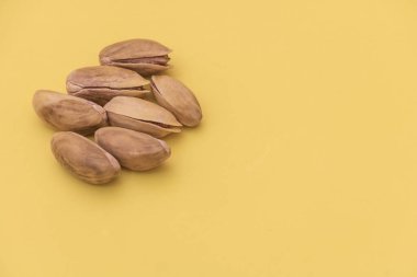 Sarı arka planda, fotokopi alanı olan fıstıklar. Yakın çekim görünümü