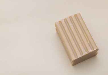 Yüzeyinde dikey oyuklar olan bir kalıp sabun, izole edilmiş beyaz bir arka planda. Minimalist stil.