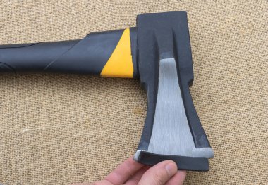 Siyah ve sarı mat kaplamalı bir balta. Bıçak keskindir, tutuşu rahattır, marangozluk gibi inşaat işlerinde kullanılmak üzere tasarlanmıştır..