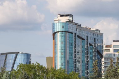 Merkezde, diğer bina ve ağaçlarla birlikte modern bir gökdelendir..