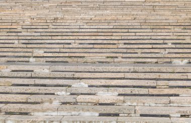 Adımların arasında görünen çatlaklar ve yosunlar olan eski yıpranmış taş merdivenler..