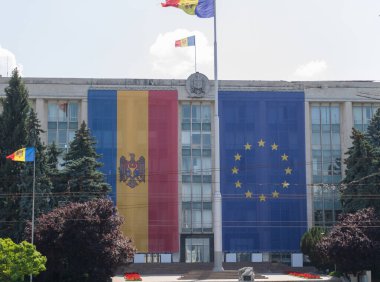 Merkezi Kişinev 'de Moldova ve Avrupa Birliği Bayrakları, Ulusal ve AB Sembolleri ile süslenmiş Hükümet Binası. Chisinau, Moldova - Haziran 01 2025.