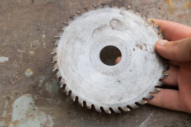 Testerenin üzerinde Eski Dairesel Testere Bıçağı Elle Tutuluyor.