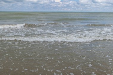 Huzurlu Deniz Dalgaları ve Kıyı Çizgisi 'nde Bulutlu Gökyüzü.