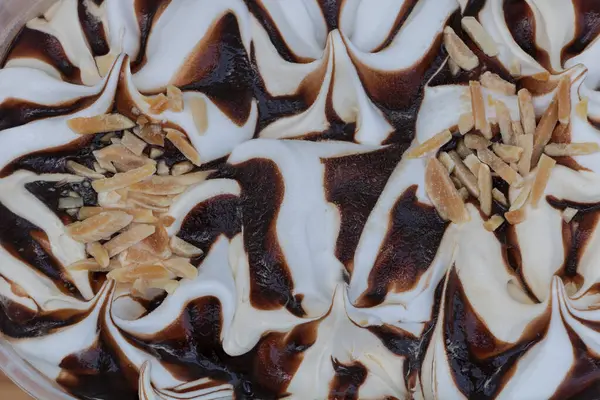 Çikolata kıvrımlı ve badem kaplamalı lezzetli vanilyalı dondurma - Yakın plan tatlı dokusu.