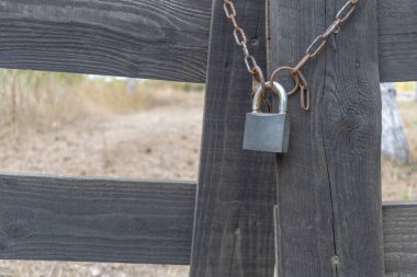 Ahşap çitlerde paslı zinciri olan eski asma kilit..