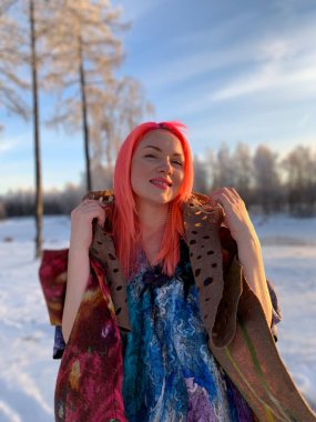 Yünlü ceketli gülümseyen kız, moda el yapımı giysiler, pembe saçlı keçeli elbise giyen kadın. Kışın, şık bir yürüyüş yapan kız.