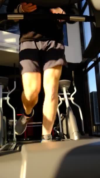 남자의 다리가 위에서 남자가 위에서 오릅니다 시뮬레이션에서 다리의 움직임 체육관에서 — 비디오