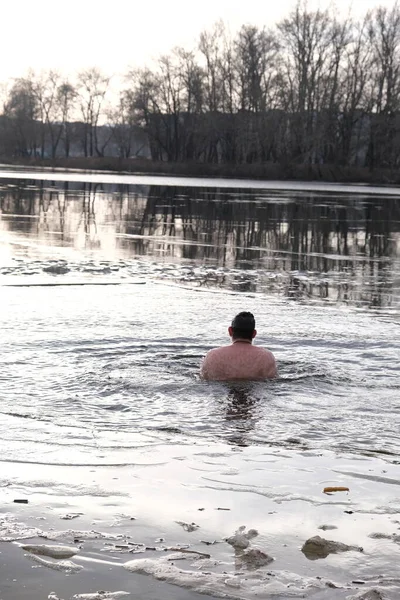 Winter swimming in ice water. January weather, Epiphany frosts and a man bathing.Athletic believing man bathes in a pond