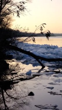 blocks of ice near the river bank. Ice drift of ice floes on rivers and lakes under the influence of current or wind. Accumulation of melt water between the bank and the edge of the ice on the river