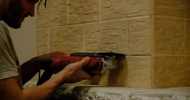 Restoration of the fireplace and tiles on the wall. Facing and cutting the grinder of the masonry surface inside the house. Repair work of the stove-maker and bricklayer indoors