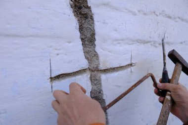 House crack repair. Strengthening the foundation of the house after the earthquake. Sewing cracks in the wall. Reinforcement with metal and staples of the building wall