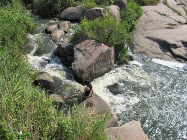 cascading waterfall in a field from a granite quarry. Sholokhov waterfall is a unique place in Ukraine