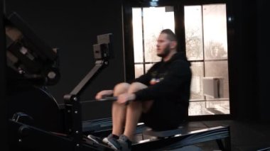 February 21, 2023 Ukraine, Dnipro. Rowing machine firm Concept 2.A man on a workout in the gym with his own weight. aeromagnetic simulator. Scandinavian traction for strength work of the back muscles