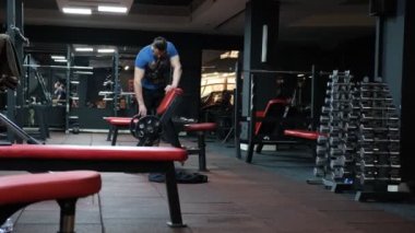 February 21, 2023. Ukraine, Dnipro. Gym. strong bodybuilder, sporty fitness man pumping up arm muscles bodybuilding workout