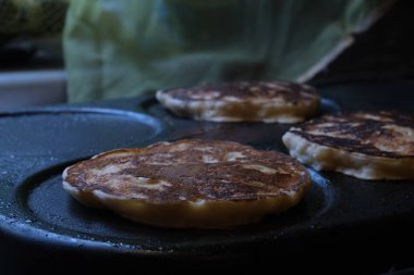 Seramik yüzeyde krep pişirmek. Yağ damlalı yağlı yiyecekler. Krep ve börek. Yiyecek buharı.