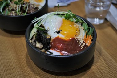 Bibimbap ve etli pilav. Kore yemeği. Baharatlı yemek. Pirincin üstüne yumurta sarısı. Lezzetli ve sağlıklı Asya yemekleri.
