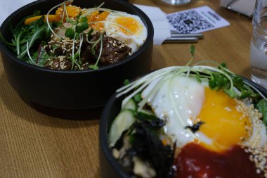 Bibimbap ve etli pilav. Kore yemeği. Baharatlı yemek. Pirincin üstüne yumurta sarısı. Lezzetli ve sağlıklı Asya yemekleri.