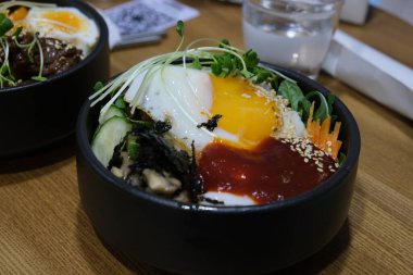 Bibimbap ve etli pilav. Kore yemeği. Baharatlı yemek. Pirincin üstüne yumurta sarısı. Lezzetli ve sağlıklı Asya yemekleri.