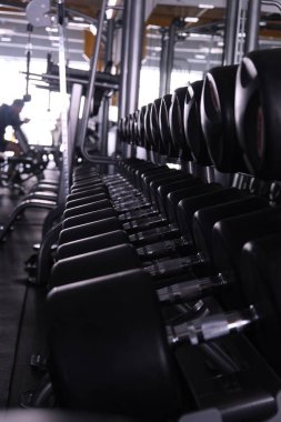 Spor salonundaki spor aletleri. Şık, parlak spor alanı. Ağır halterli genişleticiler ve simülatörler. Bench presi, güçlü bir vücut ve kilo kaybı için spor.