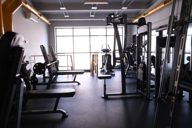 Spor salonundaki spor aletleri. Şık, parlak spor alanı. Ağır halterli genişleticiler ve simülatörler. Bench presi, güçlü bir vücut ve kilo kaybı için spor.