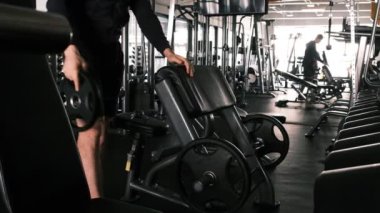  Halter göğüs presi. Sırt pozisyonunda bir simülatördeki genç bir atlet kollarının ve göğsünün kaslarını doldurur. Vücudun üst kısmındaki kas gruplarının eğitimi. spor salonu