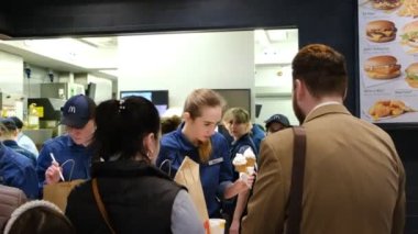 25 Nisan 2023. Ukrayna, Dnipro. McDonald 's, fast food restoranı, yazlık terasta hamburger yiyip sohbet eden insanlar. Paketleme ve teslimat emirleri. Yağlı ve yüksek kalorili yiyecekler.