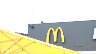 25 Nisan 2023. Ukrayna, Dnipro. McDonald 's, fast food restoranı, yazlık terasta hamburger yiyip sohbet eden insanlar. Paketleme ve teslimat emirleri. Yağlı ve yüksek kalorili yiyecekler.