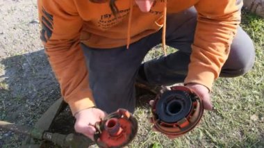 Bahçıvan çimleri biçiyor, çim biçme makinesi bölgeyi temizliyor. Bahçe budayıcı. Bahçedeki yüksek otları biçiyor.