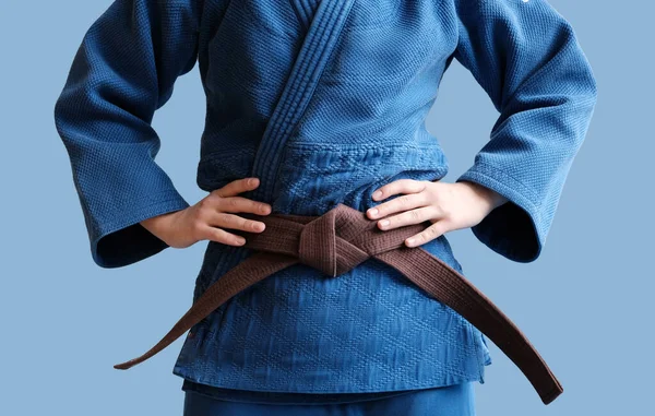 茶色のベルトをした柔道の女の子 青い着物に身を包んだ十代の少女戦士が腰を下ろしている 日本の武道 武道の訓練の過程 健康的なライフスタイル スポーツコンセプト — ストック写真